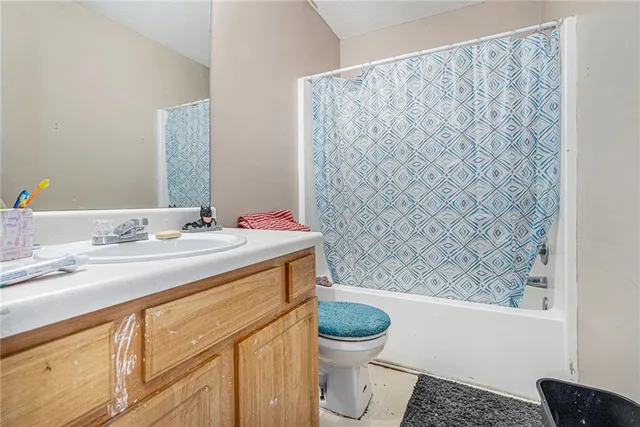 a bathroom with a granite countertop sink and a toilet