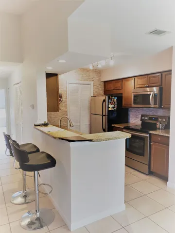 a kitchen with stainless steel appliances granite countertop a sink and a refrigerator