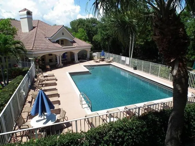 a view of a house with pool and chairs