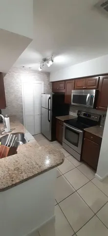 a kitchen with kitchen island granite countertop a stove and a refrigerator