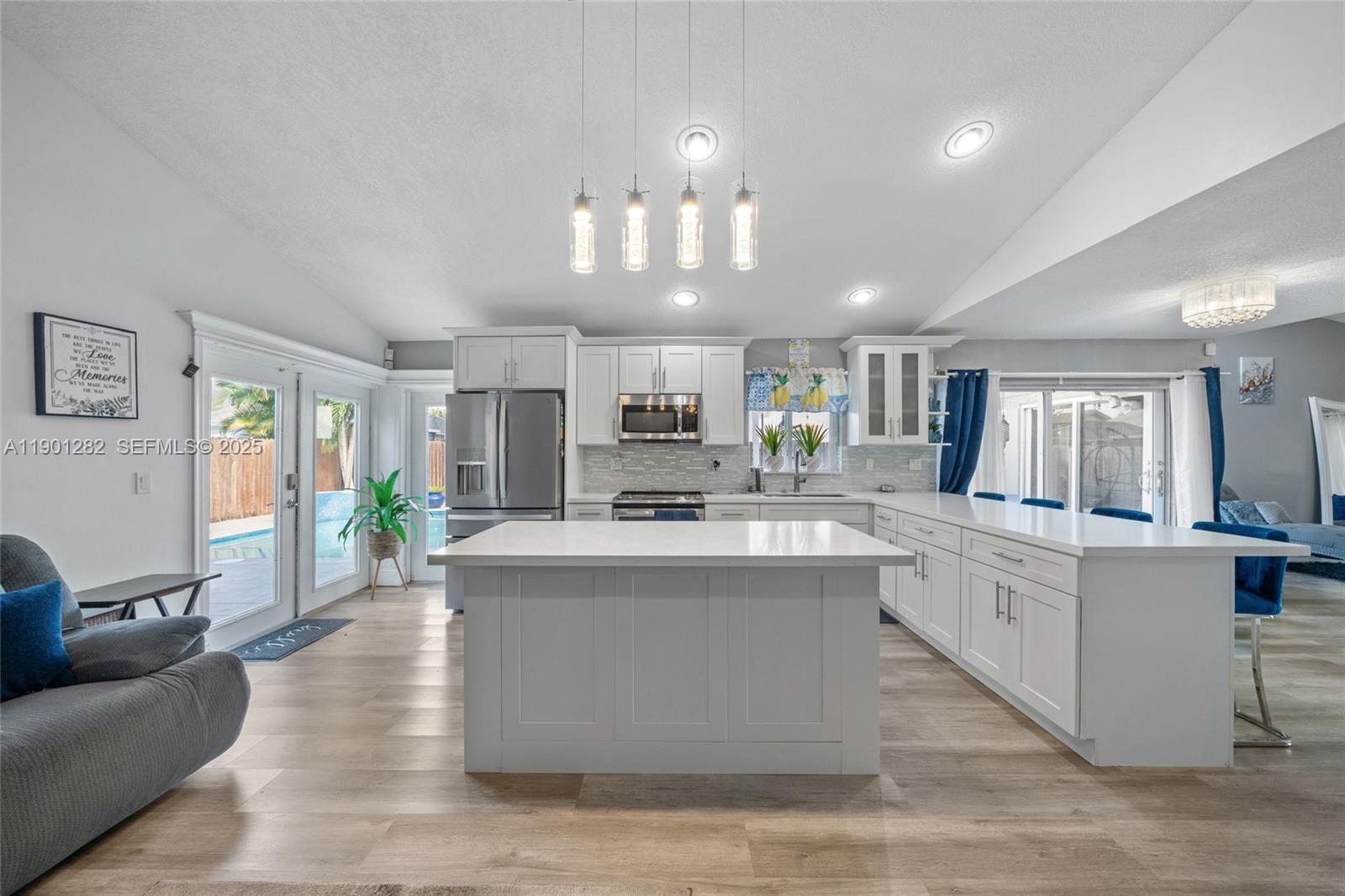 7461 Northwest 36th Street Lauderhill, FL 33319 - Photo 10 of 24 a large kitchen with kitchen island a large counter space a sink appliances and living room view