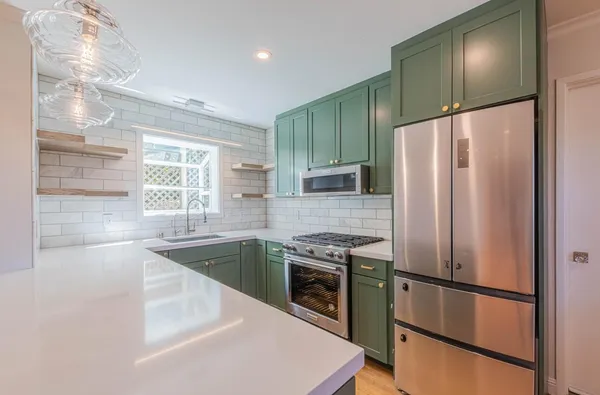 a kitchen with stainless steel appliances granite countertop a refrigerator a sink and a stove