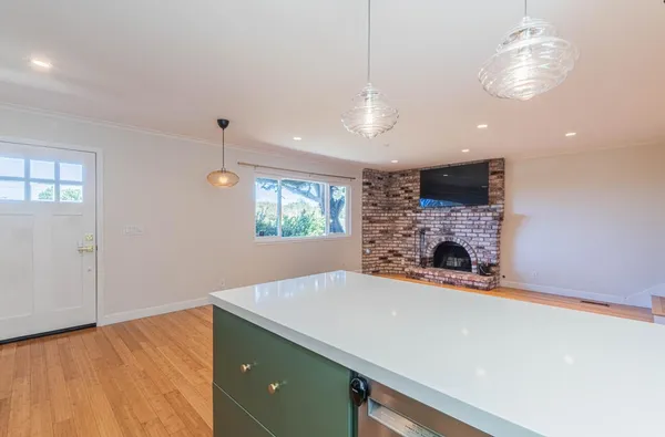 a open kitchen with a stove and a chandelier