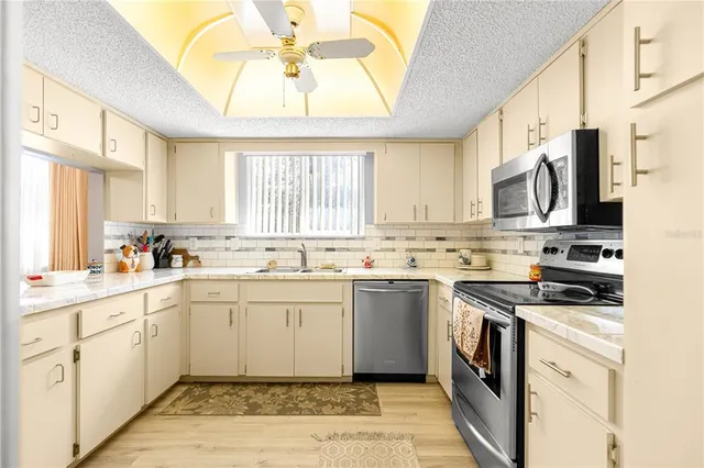 a kitchen with stainless steel appliances a stove a sink and a microwave