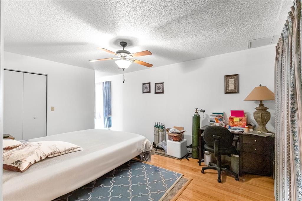 10987 Southwest 86th Terrace Ocala, FL 34481 - Photo 20 of 40 a bedroom with a bed and a chandelier