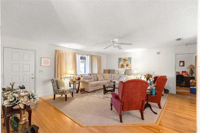 a living room with furniture a wooden floor and a window