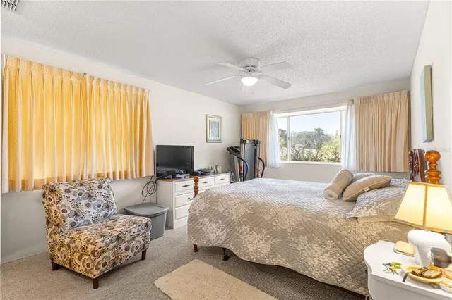 a bedroom with bed and a large window