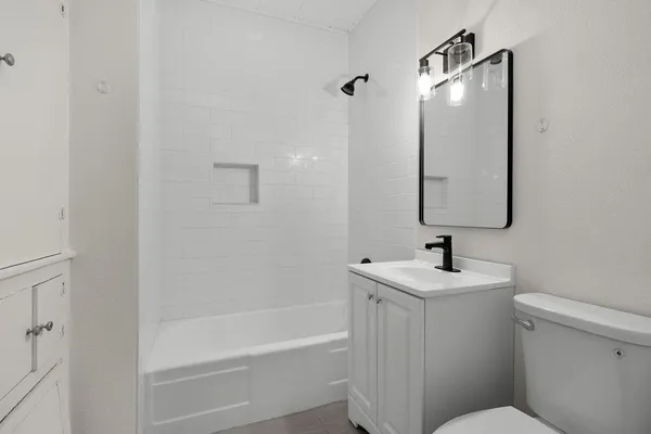 a bathroom with a sink toilet vanity and tub