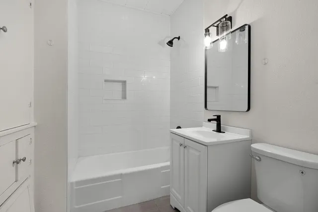 a bathroom with a sink toilet vanity and tub