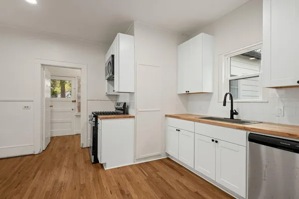 a kitchen with a sink cabinets and wooden floor