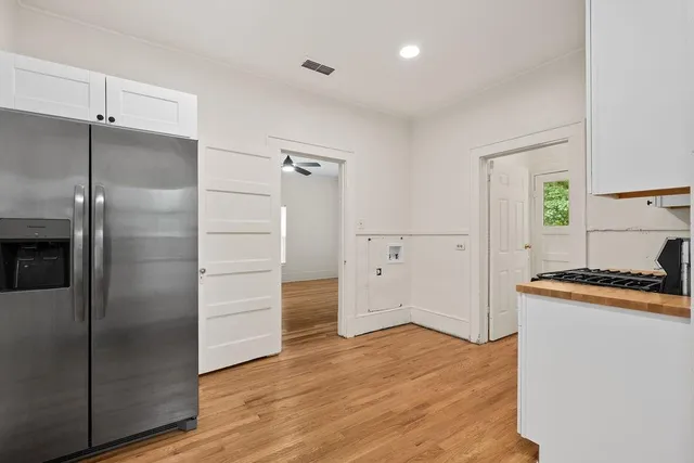 a kitchen with granite countertop a refrigerator and a stove top oven