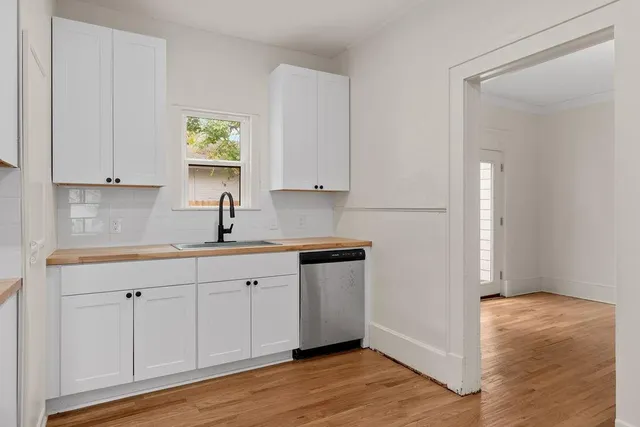 a kitchen with white cabinets and sink