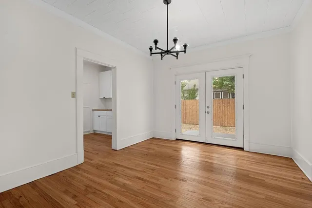 a view of empty room with wooden floor and ceiling fan