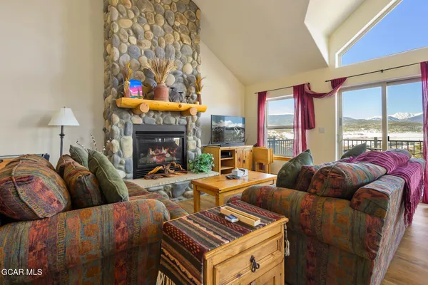 a living room with furniture a fireplace and a large window