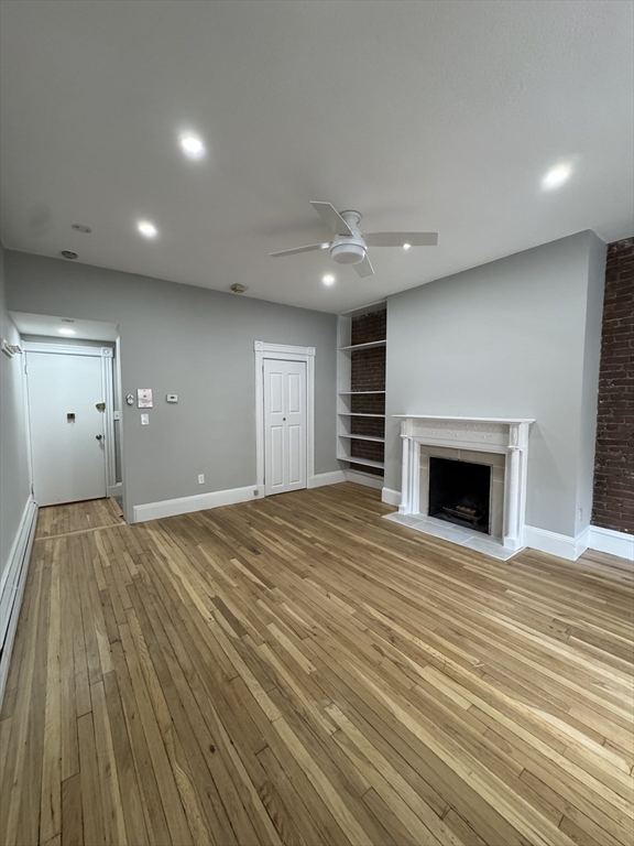 198 St Botolph Street, Unit 2 Boston, MA 02115 - Photo 5 of 10 an empty room with wooden floor fireplace and windows