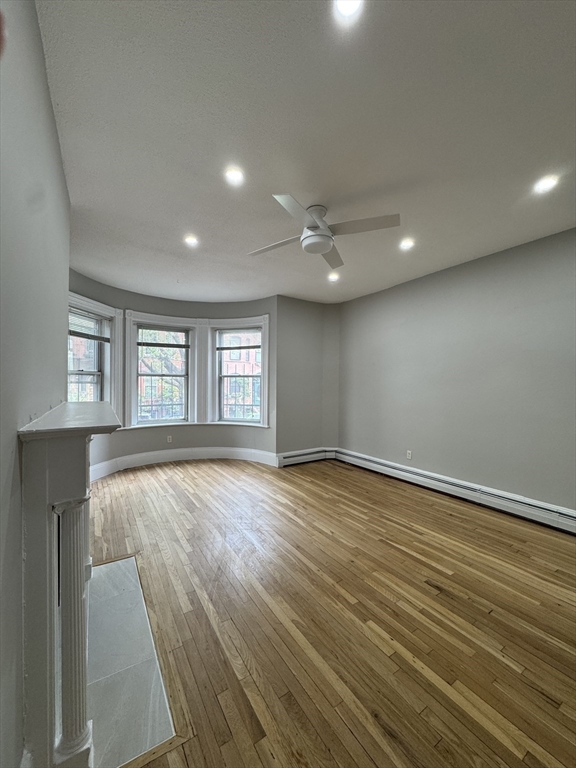 198 St Botolph Street, Unit 2 Boston, MA 02115 - Photo 8 of 10 an empty room with wooden floor and windows