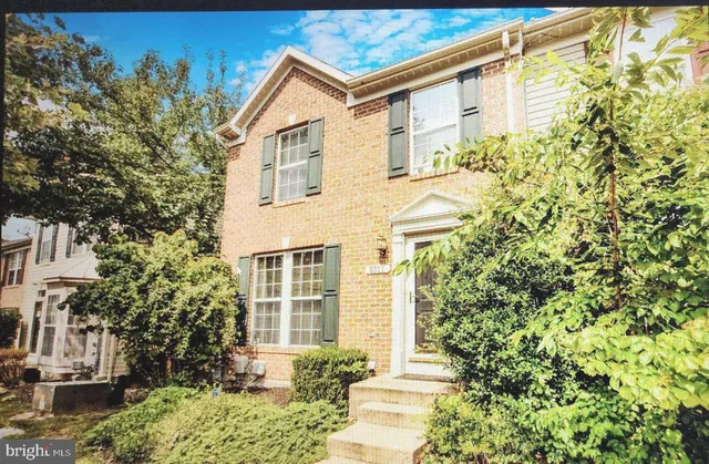 a view of a white house with large windows and a tree