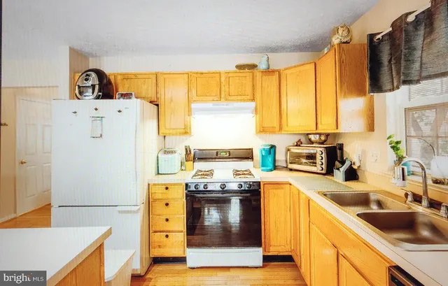 a kitchen with a stove a sink and a refrigerator