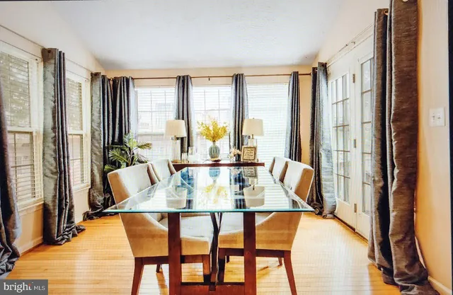 a dining room with furniture and large windows