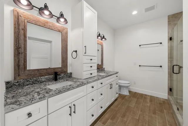 a bathroom with a granite countertop sink toilet and shower