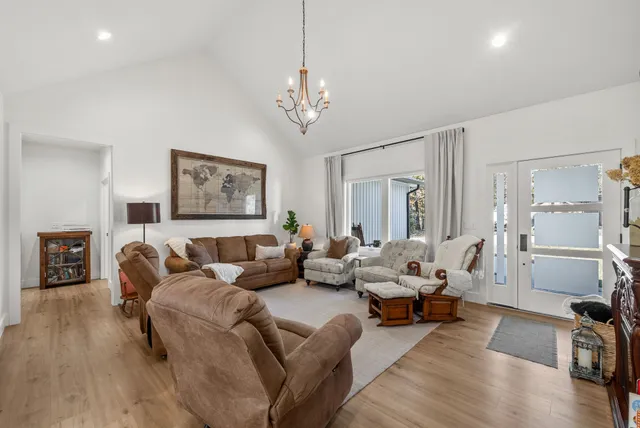 a living room with furniture a wooden floor and a chandelier