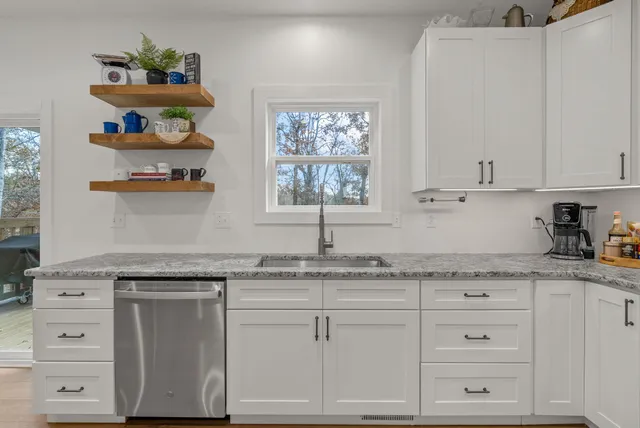 a kitchen with granite countertop white cabinets and white appliances