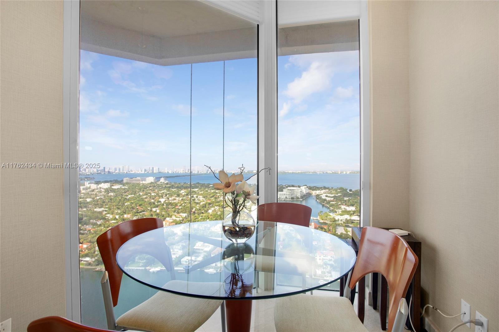 4775 Collins Avenue, Unit 4005 Miami Beach, FL 33140 - Photo 11 of 26 a dining room with furniture and a floor to ceiling window