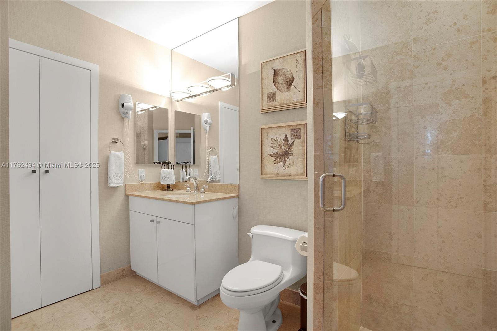 4775 Collins Avenue, Unit 4005 Miami Beach, FL 33140 - Photo 19 of 26 a bathroom with a toilet sink and shower