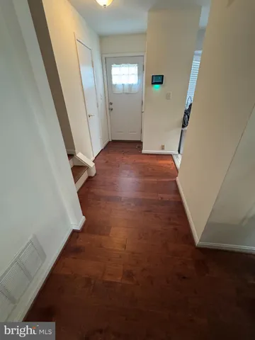 an empty room with wooden floor and a window