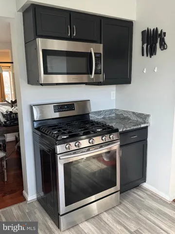 a kitchen with stainless steel appliances granite countertop a stove microwave and oven