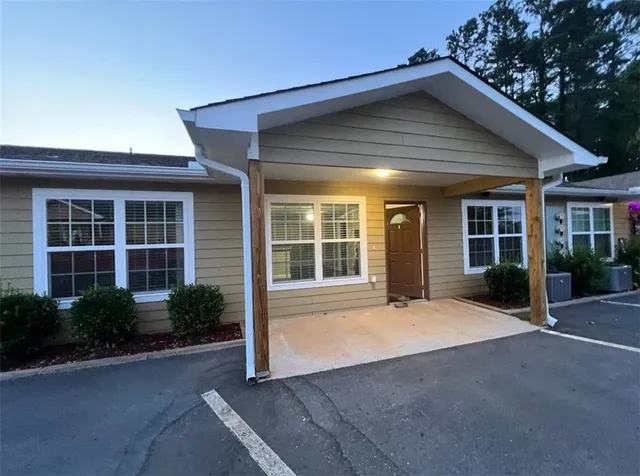 a view of house with backyard and glass windows