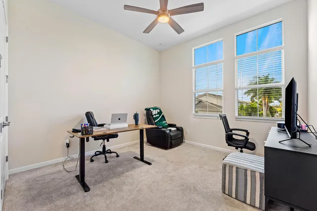 a view of a workspace with furniture and a window