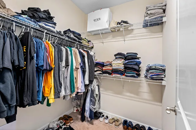a view of walk in closet with clothes and shoes