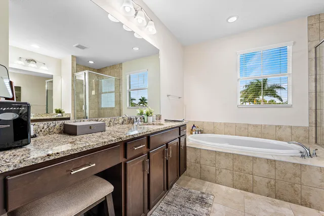 a bathroom with a granite countertop bathtub sink and mirror
