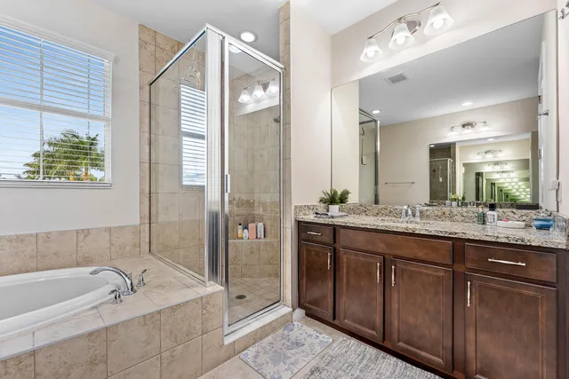 a bathroom with a tub a double vanity sink and mirror
