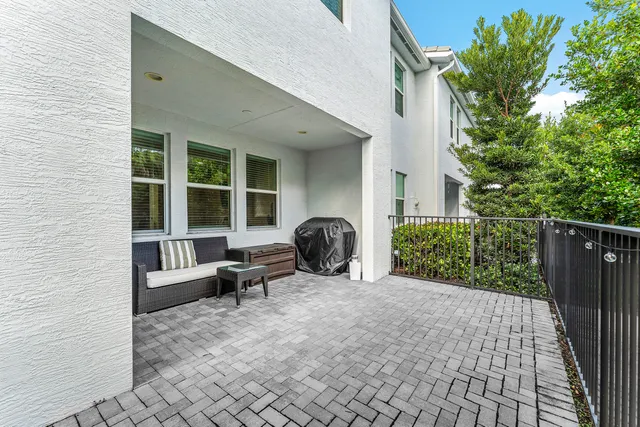 a view of a patio with chairs and potted plants
