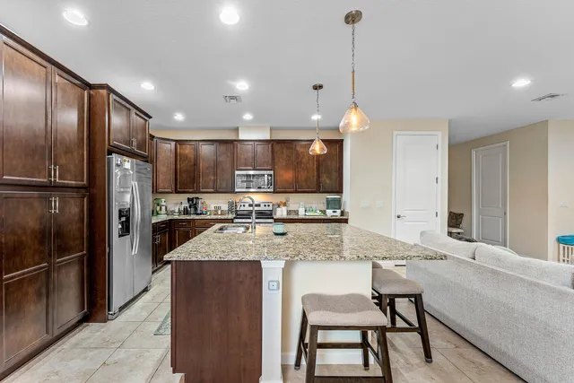 a kitchen with stainless steel appliances granite countertop a sink refrigerator and cabinets