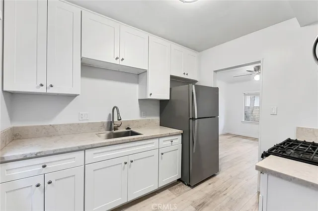 a view of empty room with wooden floor and ceiling fan