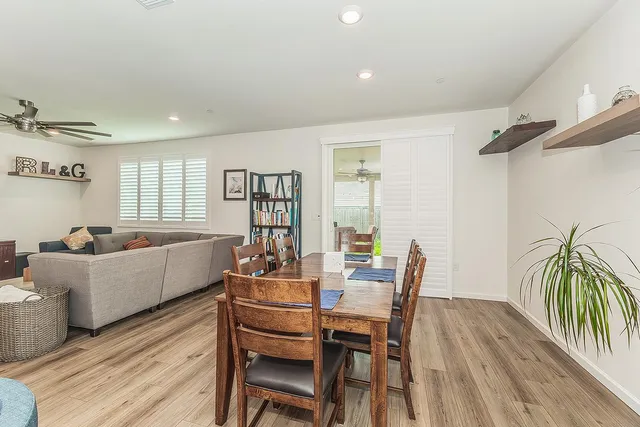a living room with furniture a wooden floor and a potted plant
