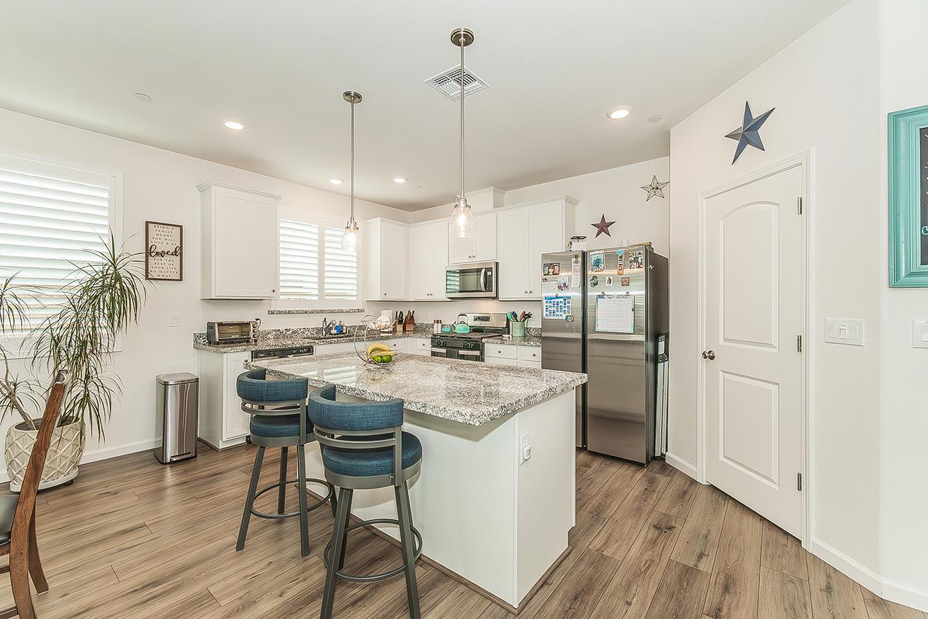 644 Rock Crest Avenue Madera, CA 93636 - Photo 13 of 38 a kitchen with a table chairs refrigerator and microwave