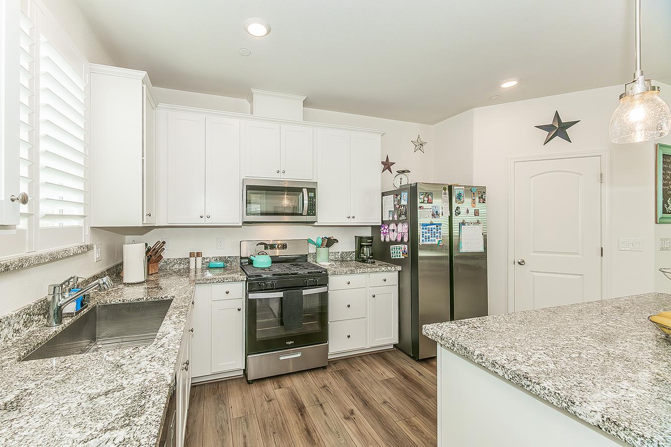 644 Rock Crest Avenue Madera, CA 93636 - Photo 15 of 38 a kitchen with stainless steel appliances granite countertop a sink stove and refrigerator