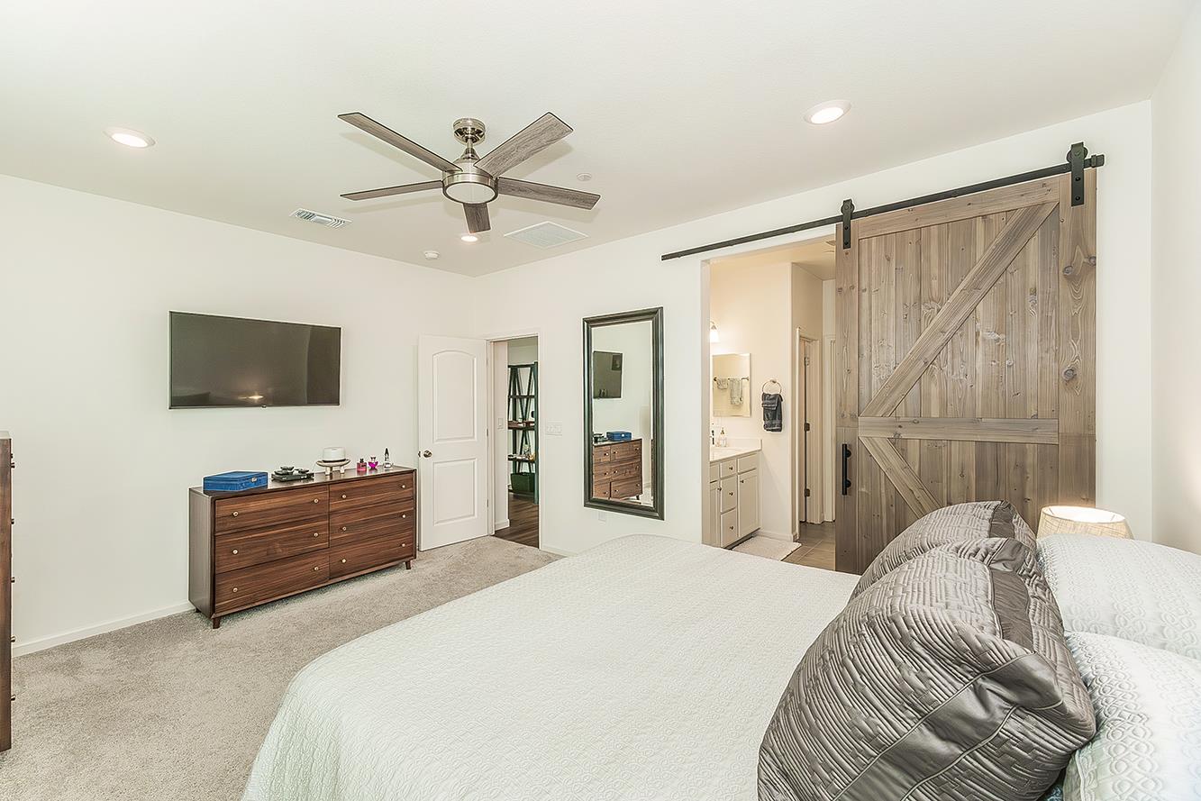 644 Rock Crest Avenue Madera, CA 93636 - Photo 20 of 38 a bedroom with a bed and a flat screen tv