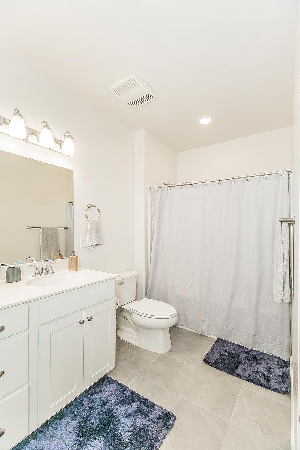 644 Rock Crest Avenue Madera, CA 93636 - Photo 29 of 38 a bathroom with a double vanity sink toilet and a mirror