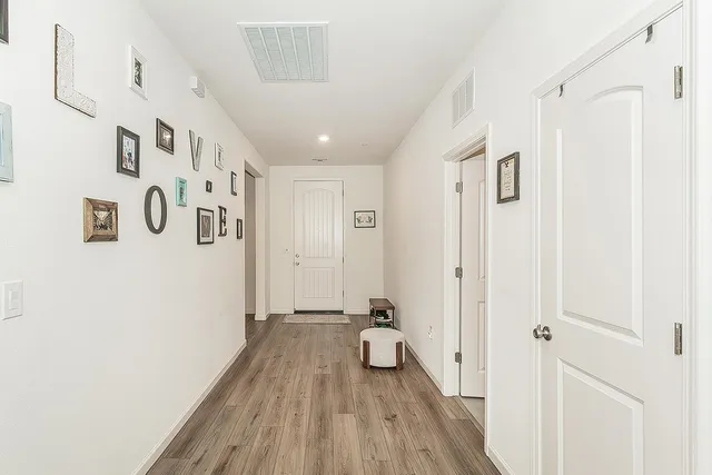 a view of a hallway with wooden floor and staircase