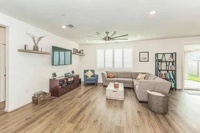 a living room with furniture and a wooden floor