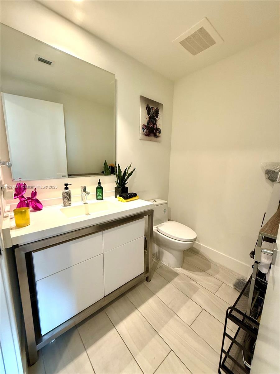 2000 Metropica Way, Unit 1605 Sunrise, FL 33323 - Photo 4 of 43 a bathroom with a sink toilet and a mirror