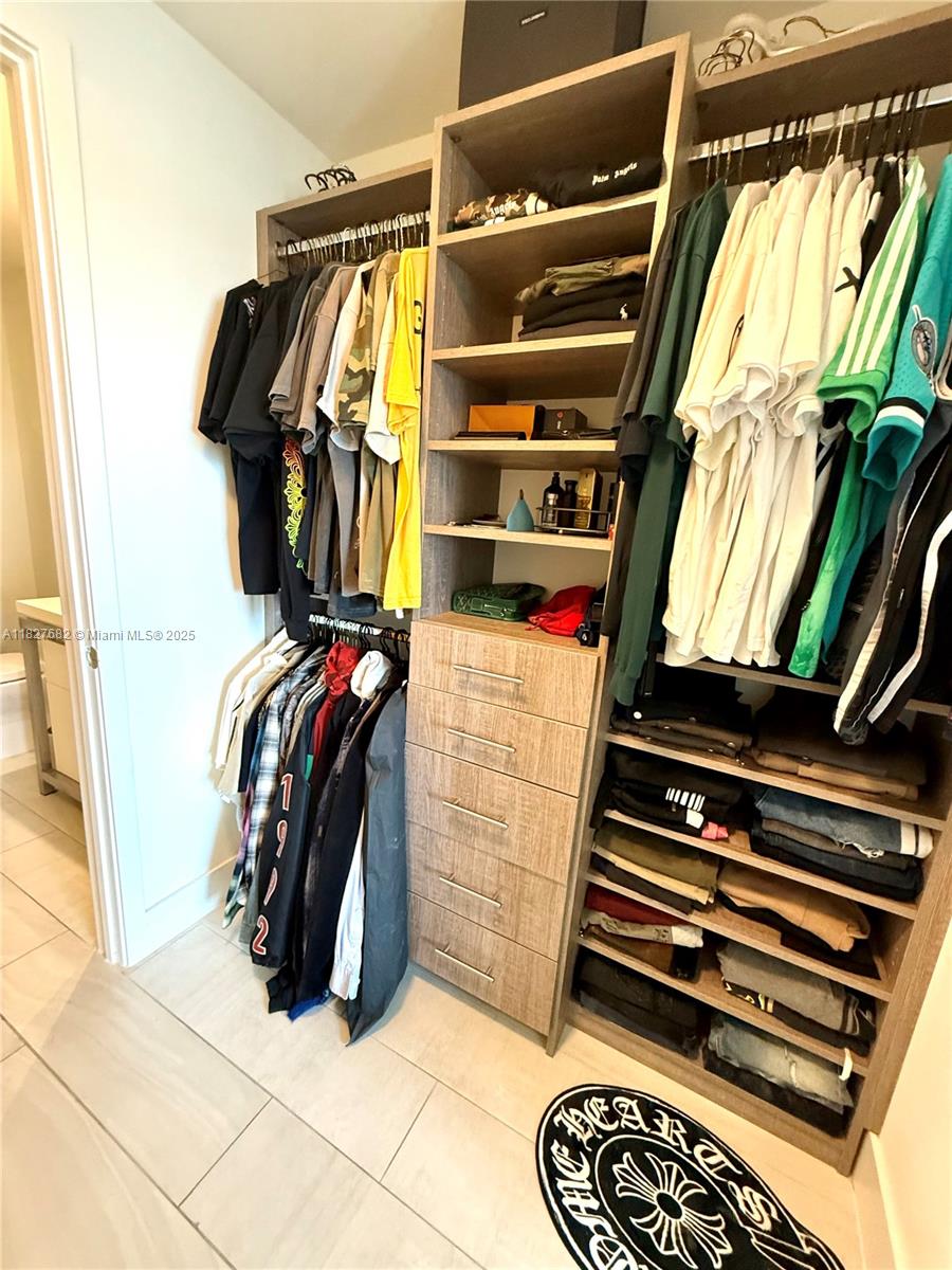 2000 Metropica Way, Unit 1605 Sunrise, FL 33323 - Photo 7 of 43 a view of walk in closet with clothes and shoes