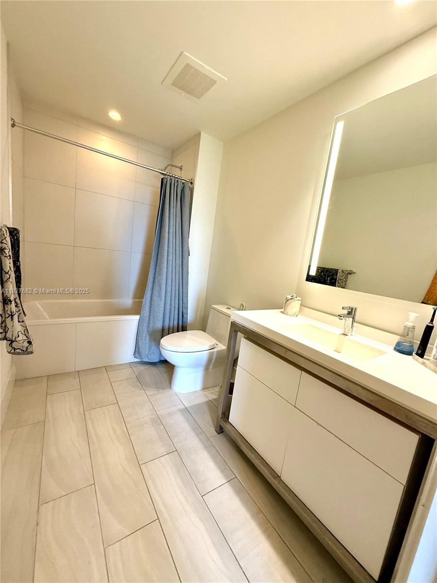 2000 Metropica Way, Unit 1605 Sunrise, FL 33323 - Photo 8 of 43 a bathroom with a sink a toilet a mirror and shower
