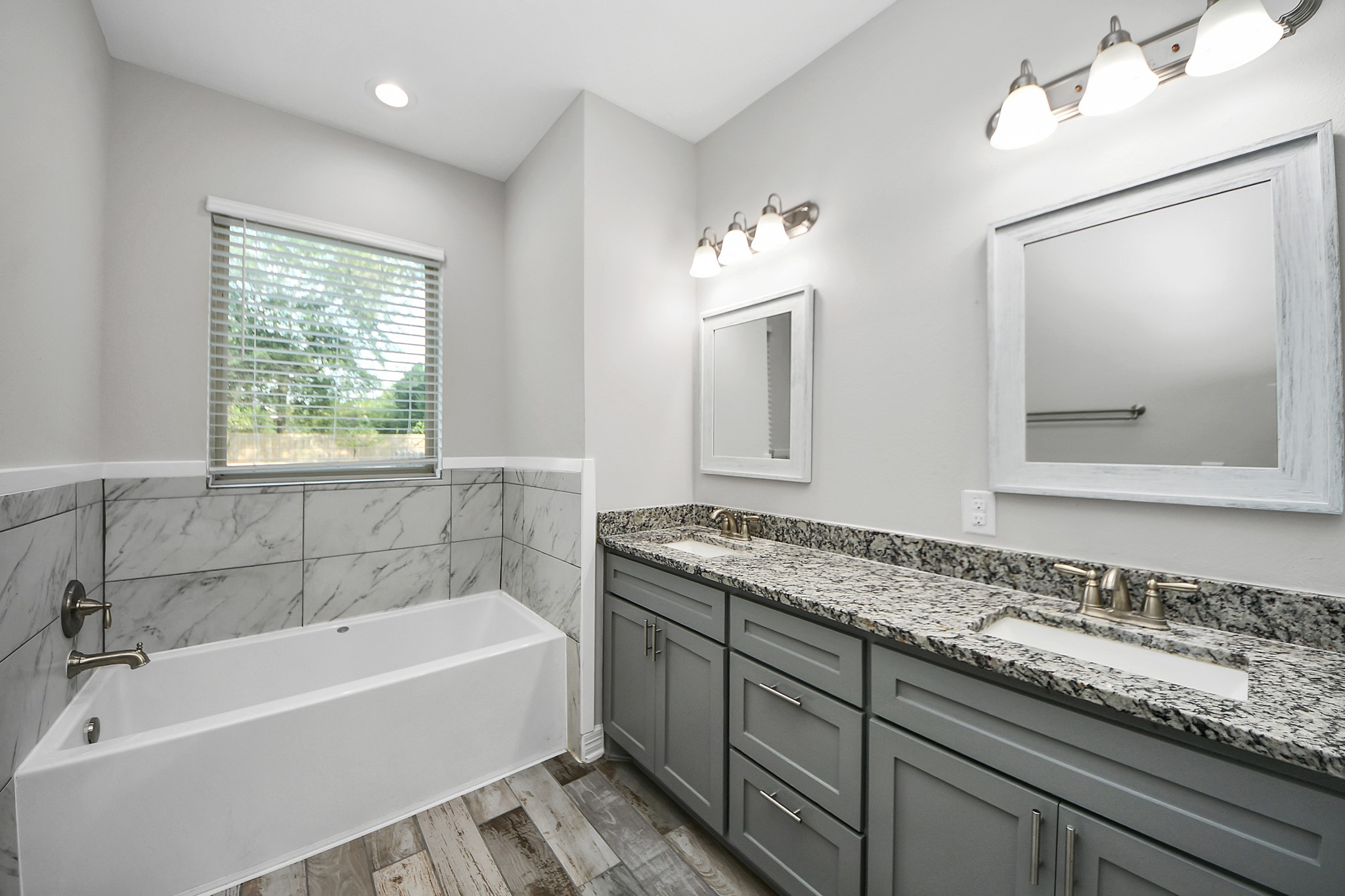 25450 Killarney Road Hempstead, TX 77445 - Photo 12 of 34 a bathroom with a granite countertop tub a double vanity sink and mirror