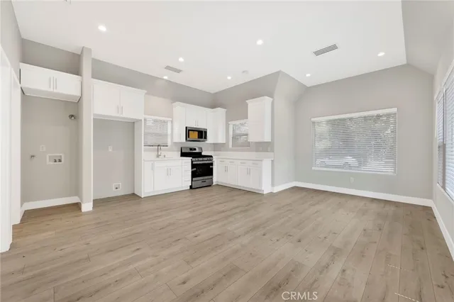 a view of kitchen with wooden floor and electronic appliances